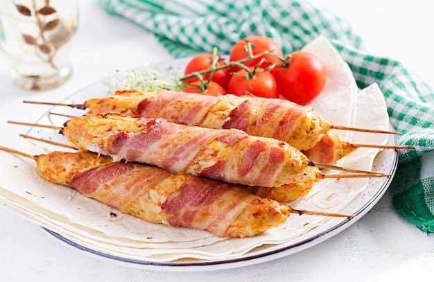 Foto gratuita lula kebab macinato di tacchino alla griglia (pollo) con zucca avvolta in pancetta sul piatto.