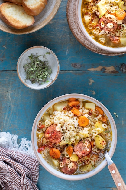 Minestrone soup in a pan on a light table top view Italian soup with pasta and seasonal vegetables Delicious vegetarian food concept