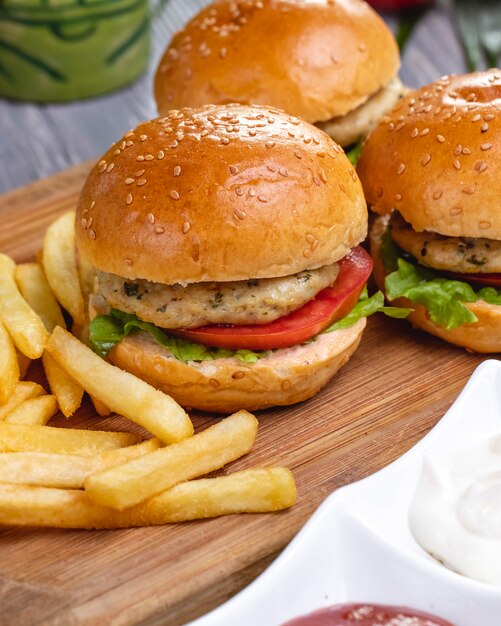 Mini burgers chicken tomato lettuce french fries side view