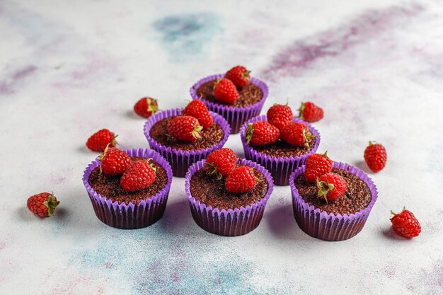 Mini chocolate souffle cupcakes with raspberries.