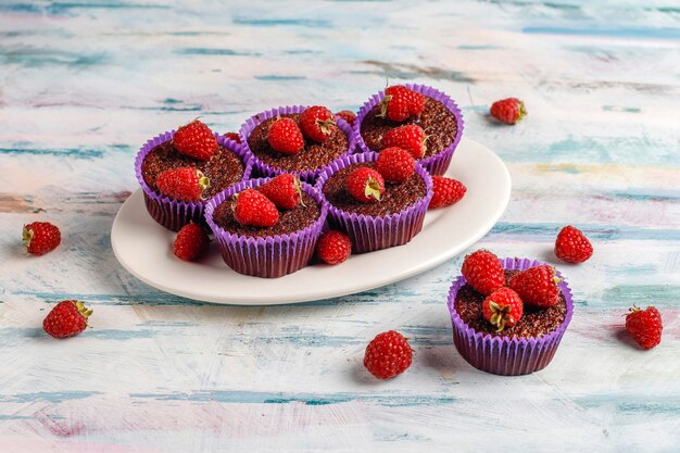 Mini chocolate sufle cupcakes with raspberries.