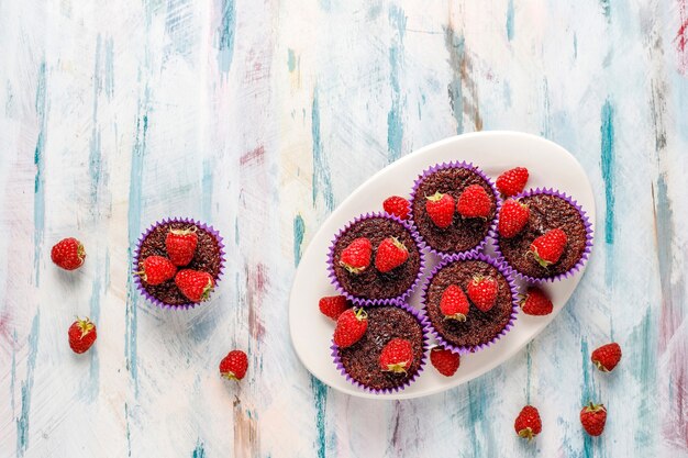 Mini chocolate sufle cupcakes with raspberries.