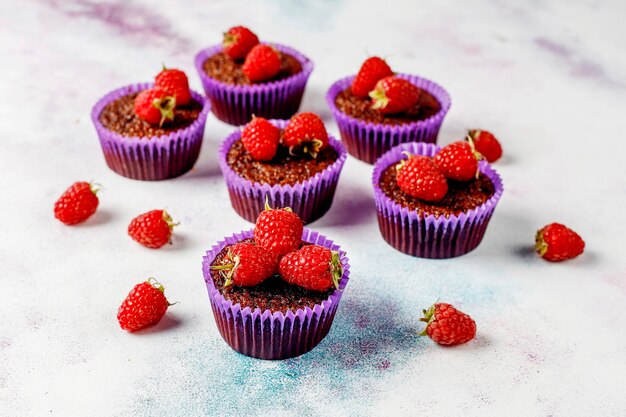 Foto gratuita mini cupcakes al cioccolato sufle con lamponi.