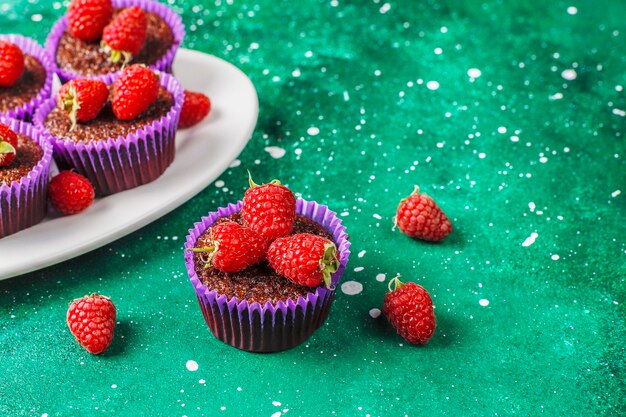 Mini chocolate sufle cupcakes with raspberries.