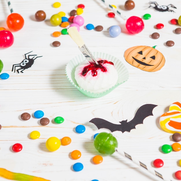 Foto gratuita mini muffin vicino a piccole caramelle, pipistrelli, ragni e bonbon