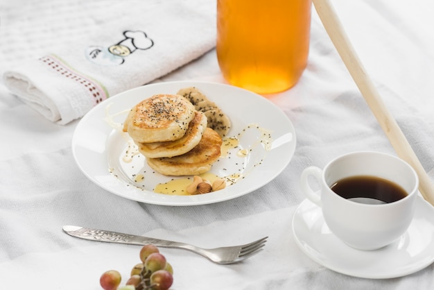 Mini pancakes with banana; honey and chia seeds on plate