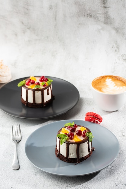 大理石の背景上のtopcにフルーツとチョコレートの釉薬が入ったミニラウンドスフレケーキ ペストリーカフェやカフェメニューの壁紙 垂直 プレミアム写真 大理石の背景上のtopcにフルーツとチョコレートの釉薬が入ったミニラウンドスフレケーキ ペストリーカフェやカフェメニューの壁紙 垂直 プレミアム写真