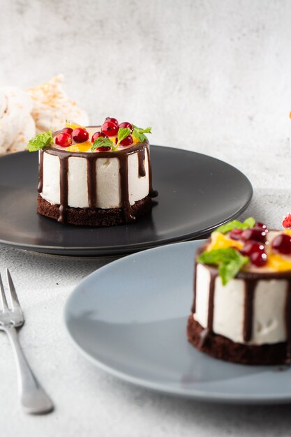 大理石の背景にテーブルの上の皿に白いココナッツクリームとおいしいチョコレートケーキ ペストリーカフェやカフェメニューの壁紙 垂直 プレミアム写真