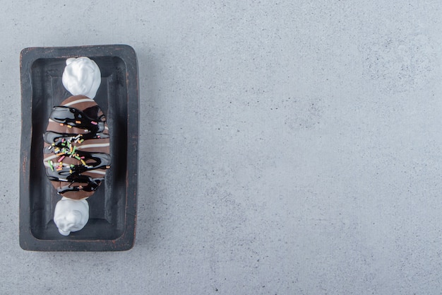 검정 접시에 스프링클이 있는 맛있는 미니 초콜릿 케이크. 고품질 사진