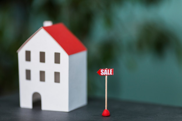 Miniature model of house real estate for sale against blurred backdrop