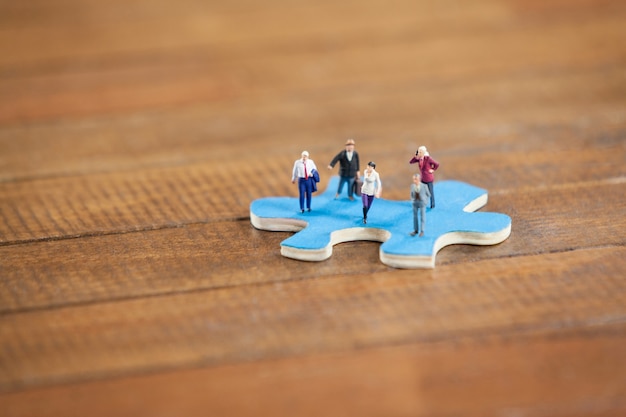 Miniature people on a jigsaw puzzle