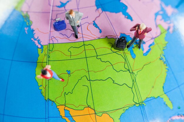 Miniature people travelling on globe