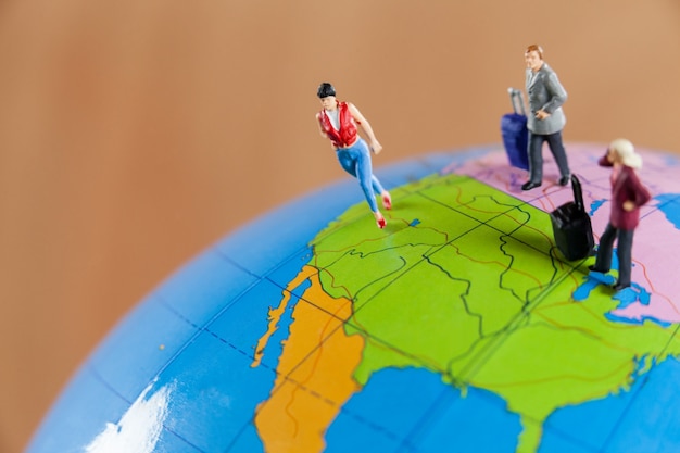 Free photo miniature people travelling on globe