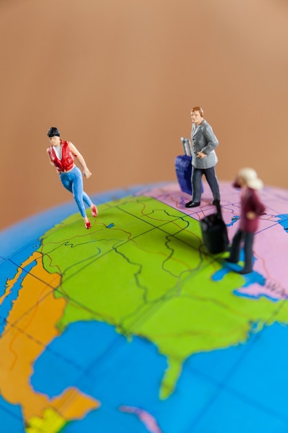 Miniature people travelling on globe