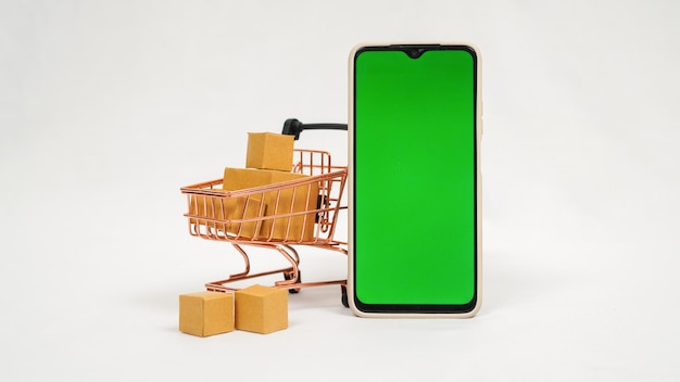 Miniature trolley full of brown boxes and smartphone isolated on white background