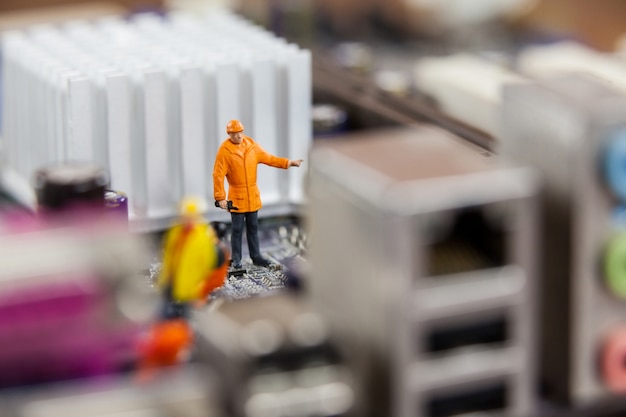 Free photo miniature workers working on chip of motherboard