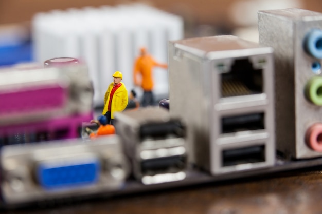 Free photo miniature workers working on chip of motherboard