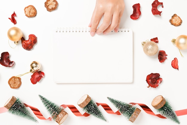겨울 크리스마스 전통 구성과 새해의 최소한의 창의적 평면 배치. 흰색 배경 복사 공간에 있는 텍스트를 위한 위쪽 보기 열린 모의 검정 전자 필기장.