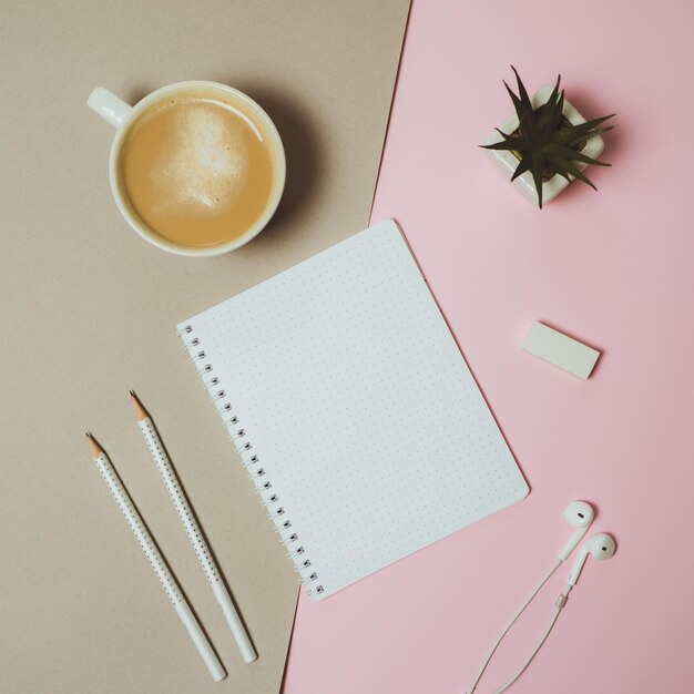 파스텔 핑크와 회색 배경에 클립보드 펜 커피 머그가 있는 최소 홈 데스크 작업 공간 플랫 레이 상단 보기