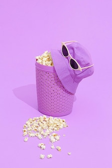 Minimal monochrome purple popcorn bucket and hat with sunglasses.  still life design.  fashion home cinema concept