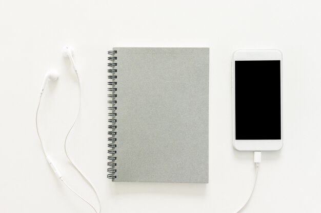 Minimal work space - Creative flat lay photo of workspace desk with sketchbook and mobile phone with blank screen on copy space white background. Top view , flat lay photography.