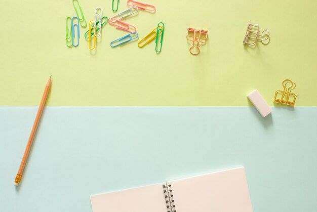 Minimal work space - Creative flat lay photo of workspace desk with sketchbook and wooden pencil on copy space green and blue pastel background. Top view , flat lay photography.