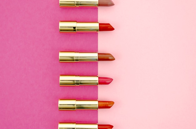 Free photo minimalist arrangement of lipsticks on pink background