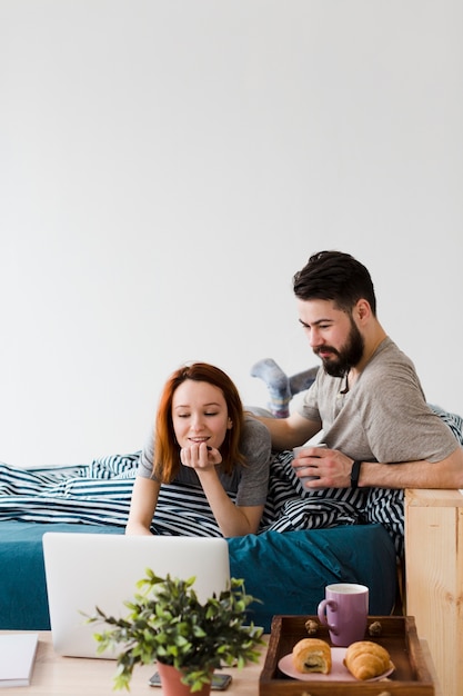 Minimalist bedroom design and couple with laptop