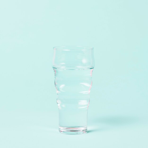 Minimalist glass of water on blue background