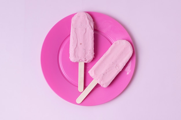 Минималистское мороженое на палочках с розовой тарелкой