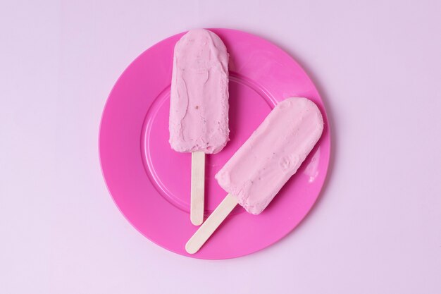 ピンクのプレートが付いている棒のミニマリストのアイスクリーム