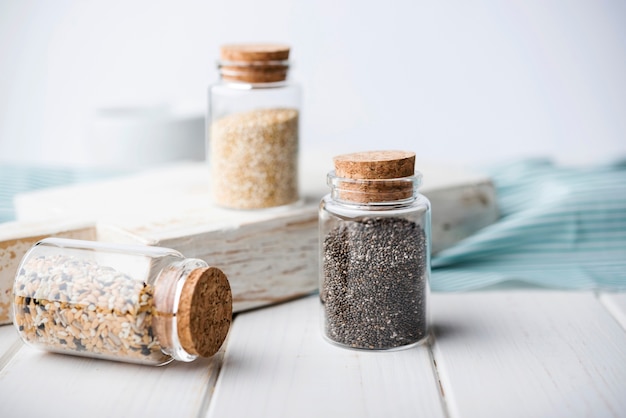 Minimalist jars filled with crushed seeds and wooden board