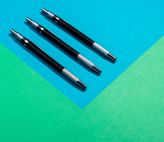 Minimalist pen tools on blue and green copy space background