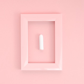 Minimalist tampon on pink background and frame