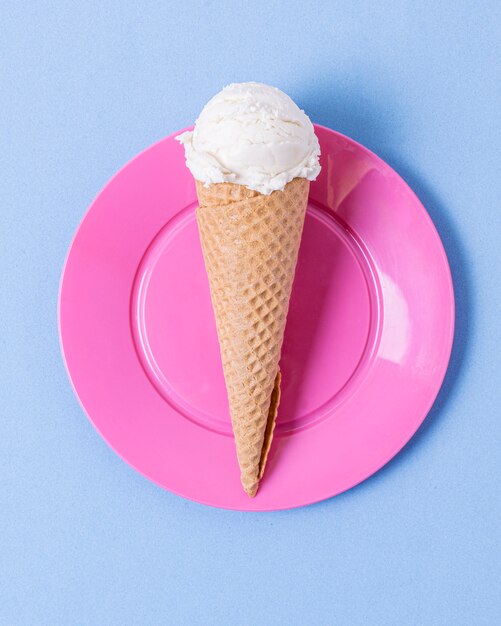 Минималистское белое мороженое на конусе и розовая тарелка
