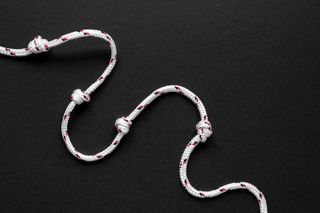 Foto gratuita minimalista nodo di corda marinaio bianco su sfondo nero