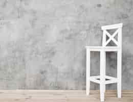 Free photo minimalist white and stool with concrete panels