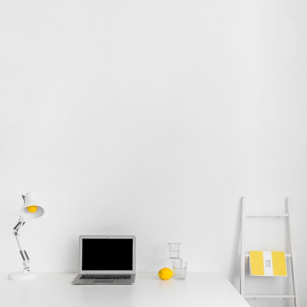 Minimalistic cabinet in white color with laptop and staircase