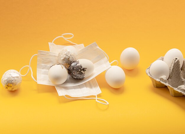Минимально оформленные пасхальные яйца замаскированы от коронавируса. Концепция безопасного празднования пасхи.