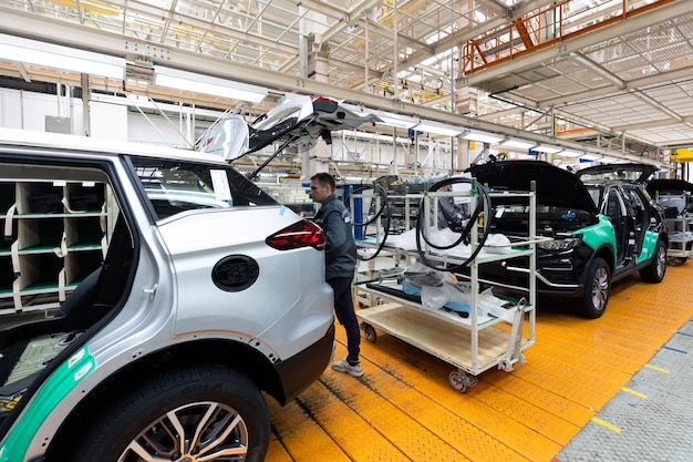 Minsk Belarus Dec 15 2021 Car bodies are on assembly line Factory for production of cars Modern automotive industry Electric car factory conveyor