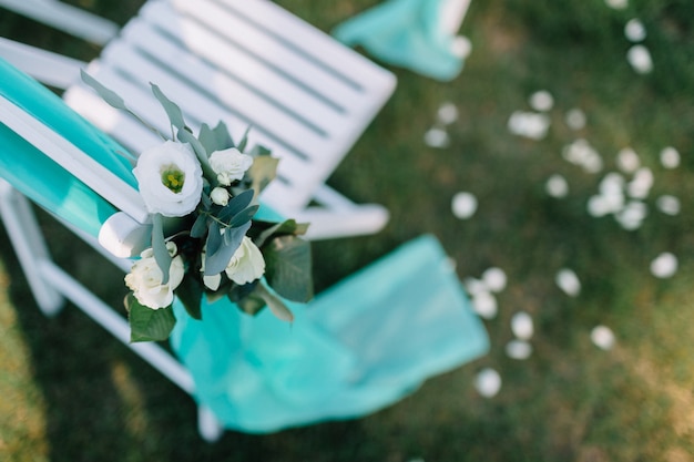 Mint cloth hangs from white chair on the lawn