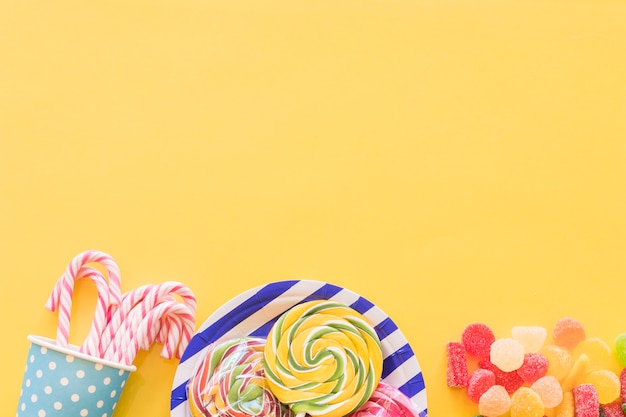 Mint sugar candies, lollipops and sugar jelly candies on yellow background