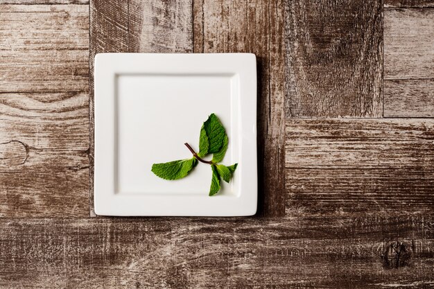 Mint on white plate on wooden