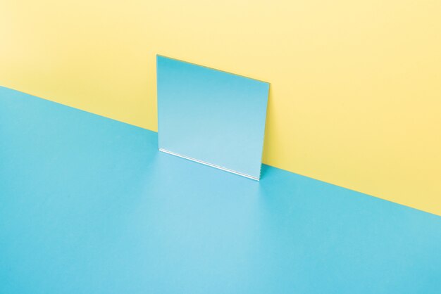 Mirror on blue table isolated on yellow