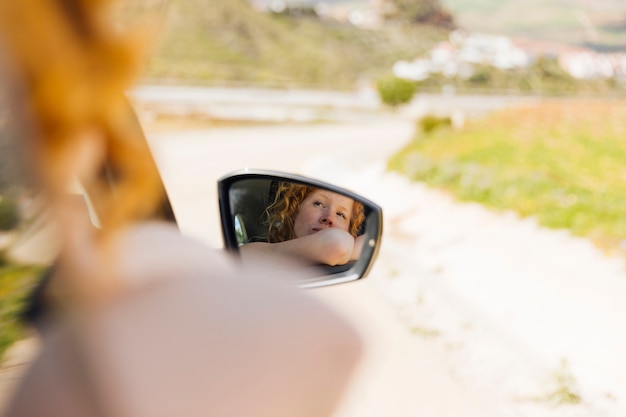 Mirror image of female riding in car
