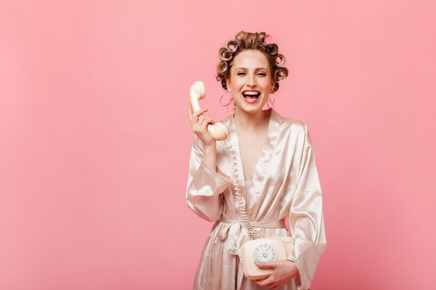 Mischievous woman in silk robe is laughing