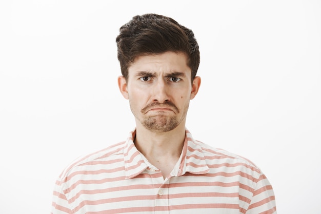 Free photo miserable sad attractive european brother with moustache and beard, being offended and upset, expressing sadness and negative emotions