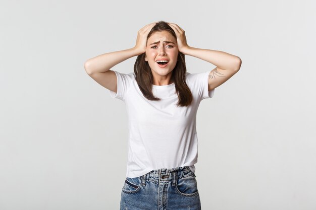 Miserable and shocked young girl panicking, looking alarmed.