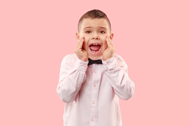 Free photo do not miss. young casual boy shouting. shout. crying emotional teen screaming on pink studio background. the male half-length portrait. human emotions, facial expression concept. trendy colors