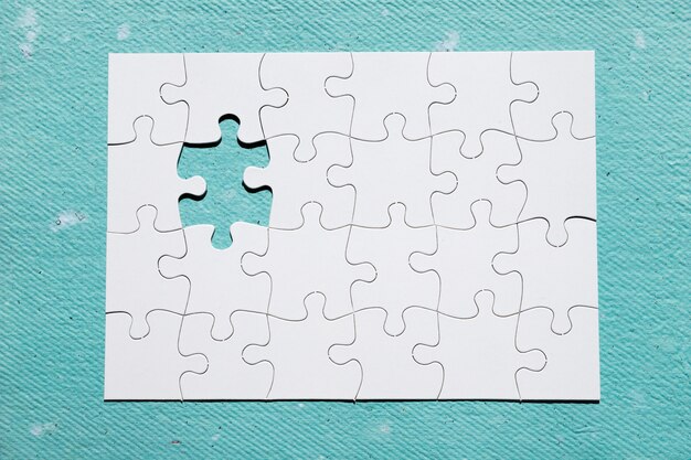 Missing piece of puzzle on blue textured backdrop